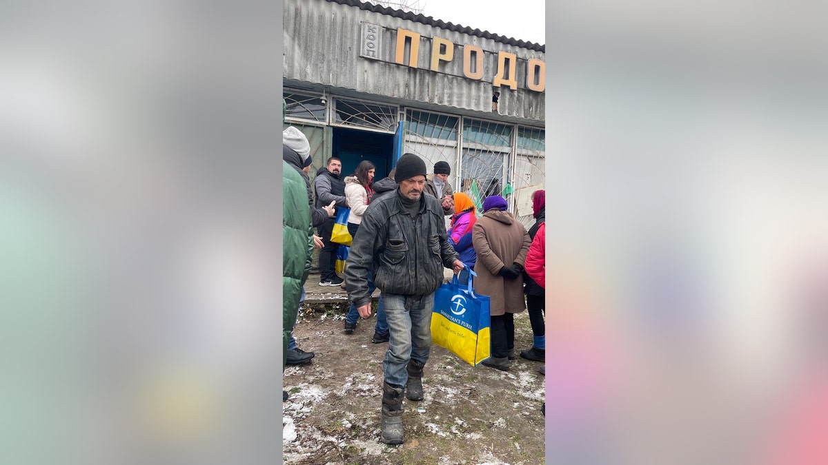Ukrainian man holding blue and yellow bag from samaritan's purse