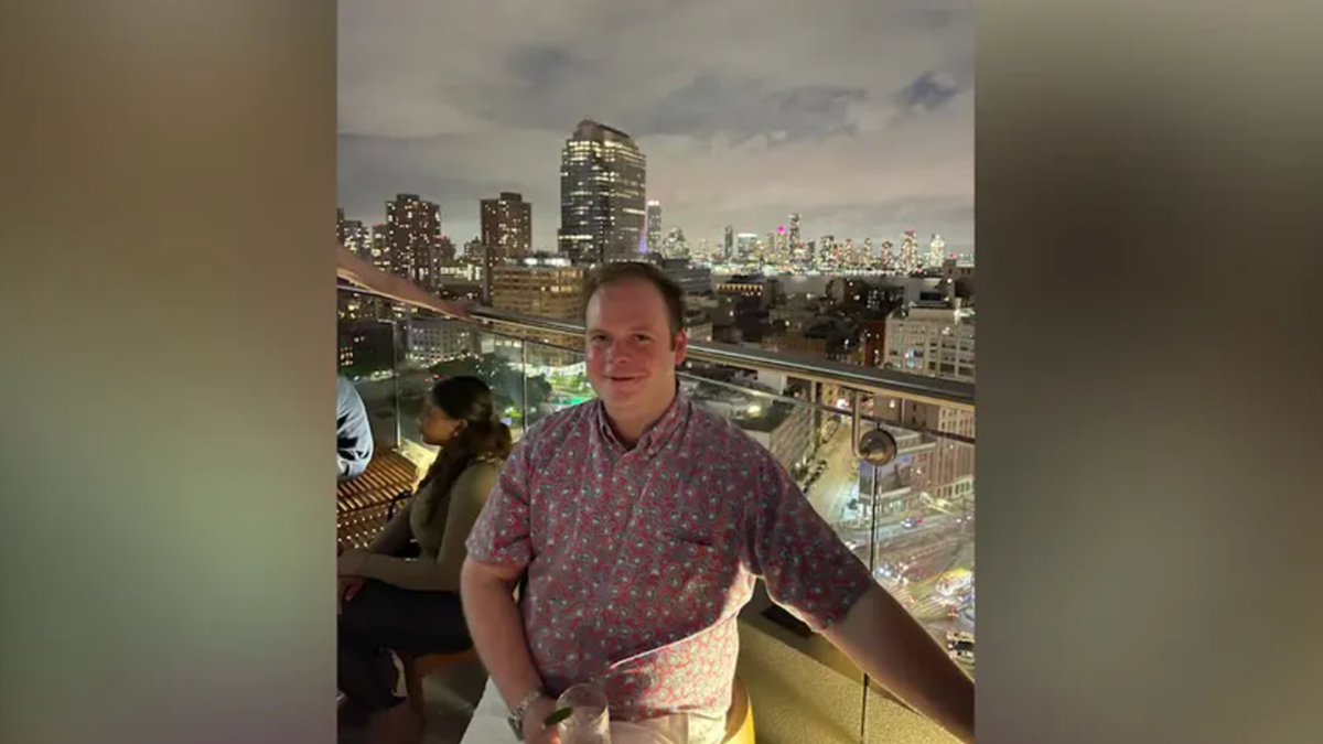 John Umberger poses on a city balcony