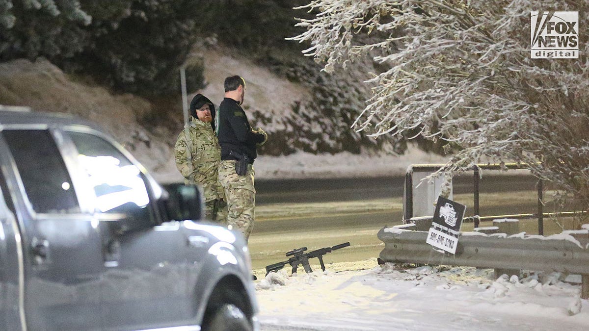 Police walk around in the snow during early morning hours