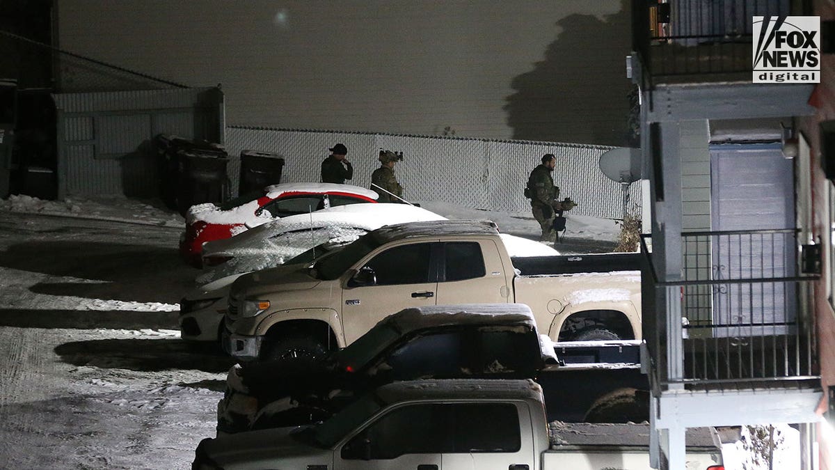 Police walk around in the snow during early morning hours