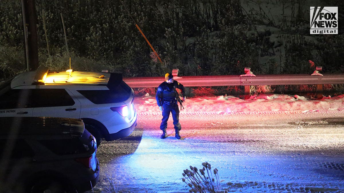 Police walk around in the snow during early morning hours