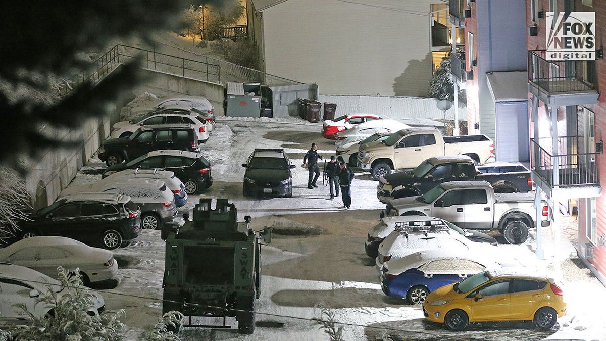 Police walk around in the snow during early morning hours