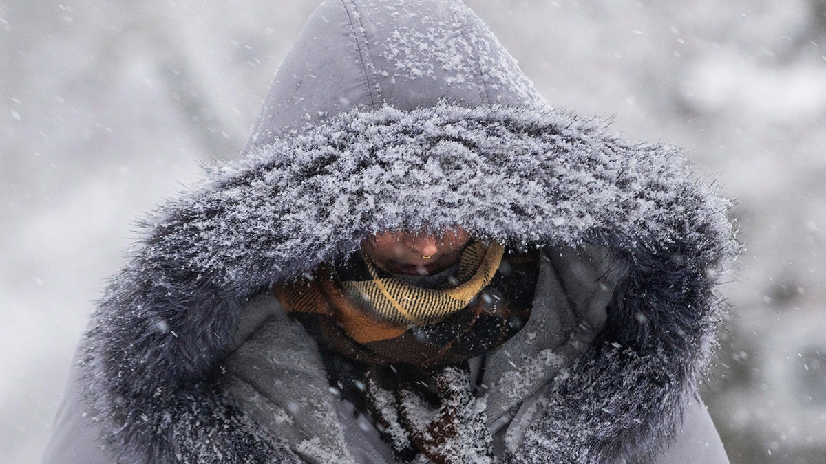 Person walking in snow with hood on