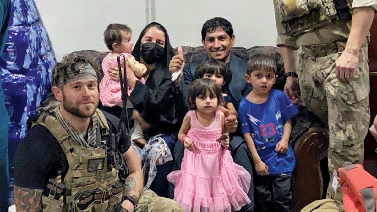 Afghan family poses for picture with soldiers in Kabul.