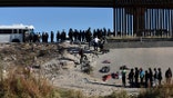 FILE - Migrants wait to get into a U.S. government bus after crossing the border from Ciudad Juarez, Mexico, to El Paso, Texas, Monday, Dec. 12, 2022. The mayor of the Texas border city declared a state of emergency Saturday, Dec. 17 over concerns about the community's ability to handle an anticipated influx of migrants across the Southern border. El Paso Mayor Oscar Leeser issued the state of emergency declaration to allow the city to tap into additional resources that are expected to become necessary after Title 42 expulsions end on Dec. 21.
