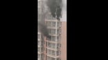 An apartment building in Xi'an, China caught fire, forcing two residents to escape to a ledge as smoke billowed from windows.