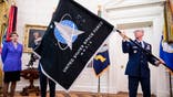 WASHINGTON, DC - MAY 15: Chief Master Sgt. Roger Towberman (R),  Space Force and Command Senior Enlisted Leader and CMSgt Roger Towberman (L), with Secretary of the Air Force Barbara Barrett present US President Donald Trump with the official flag of the United States Space Force in the Oval Office of the White House in Washington, DC on May 15, 2020. (Photo by Samuel Corum-Pool/Getty Images)