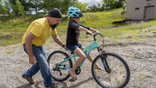 Steven Pringle, owner of Build a Bicycle - Bicycle Therapy, helps Kadence Horton, 8, of Iron River learn to ride her new bike outside of his shop in Kingsford, in Michigan's Upper Peninsula, on Friday, July 29, 2022. Pringle gave the bike and helmet to her for free after learning she and her mother had fled a domestic violence situation in New York with just the clothes on their backs. The Michigan Army veteran died in a crash while delivering free bikes to children in Florida affected by Hurricane Ian, his family said. Pringle, 57, was killed in Punta Gorda, Fla., on Nov. 23.