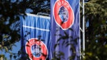 Flags with the UEFA logo waft in the garden of the headquarters of the Union of European Football Associations on Lake Geneva.