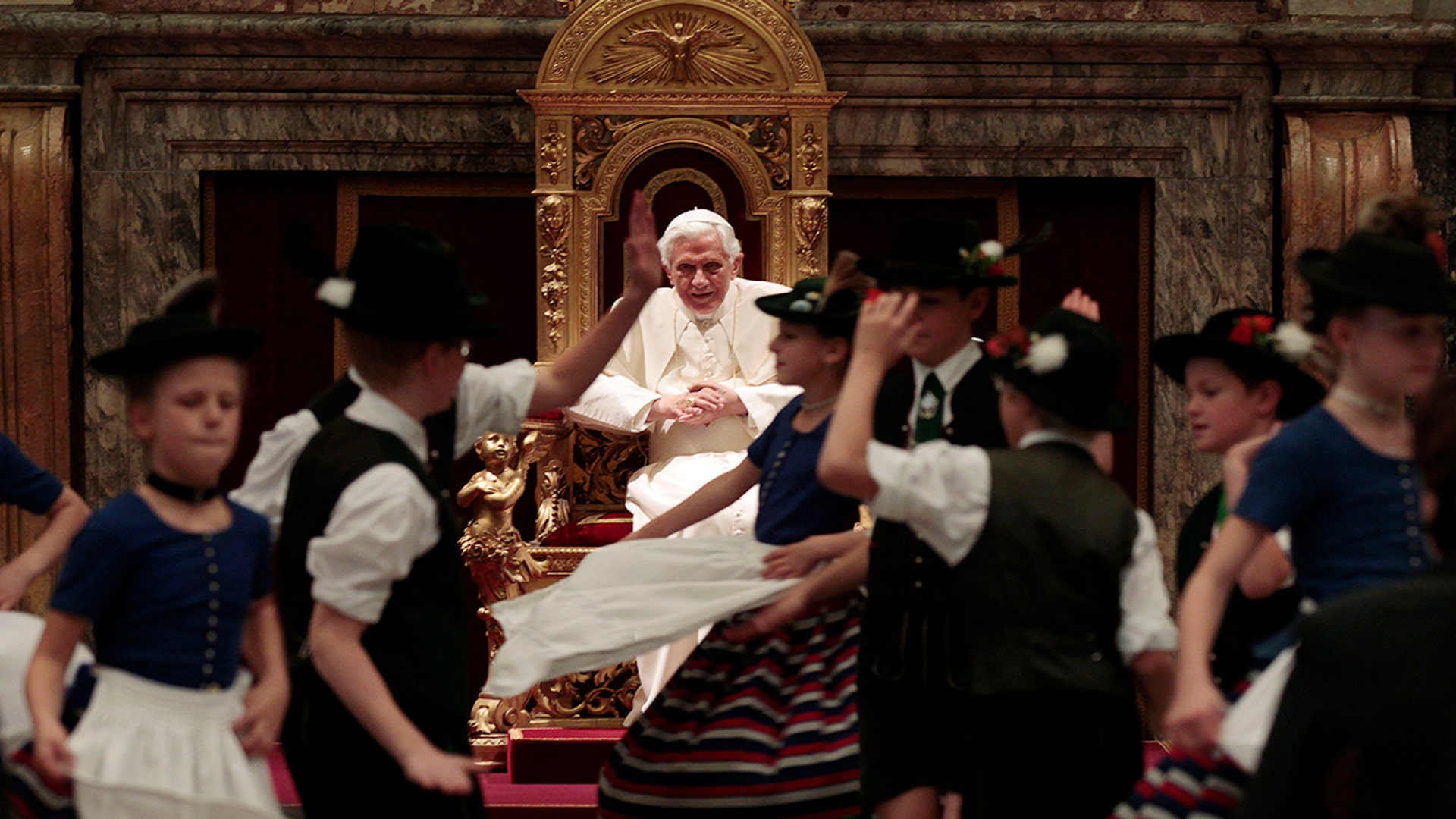 Children in traditional Bavarian folk dresses dancing for Pope Benedict