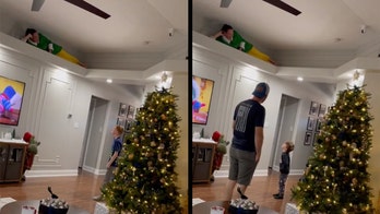 Christmas surprise: Woman climbs to ceiling, delights niece and nephews by posing like 'The Elf on the Shelf'