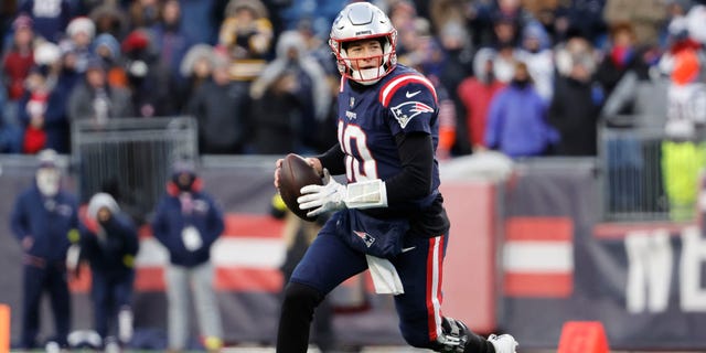 Mac Jones, do New England Patriots, tenta passar contra o Cincinnati Bengals no Gillette Stadium em 24 de dezembro de 2022 em Foxboro, Massachusetts.