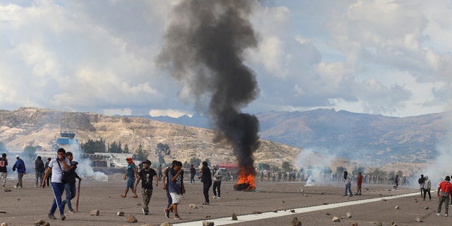 2022 年 12 月 15 日、ペルーのアヤクチョで、ペドロ カスティーヨ前大統領の追放と逮捕を受けて、暴力的な抗議活動が行われる中、空港の駐機場に立つデモ参加者。REUTERS/Miguel Gutierrez Chero.