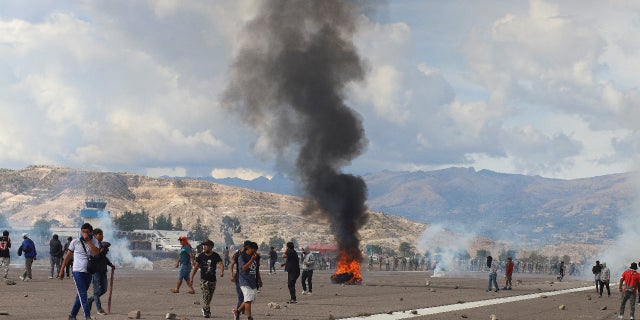 Demonstrators stand on an airport tarmac amid violent protests following the ousting and arrest of former President Pedro Castillo, in Ayacucho, Peru December 15, 2022. REUTERS/Miguel Gutierrez Chero.