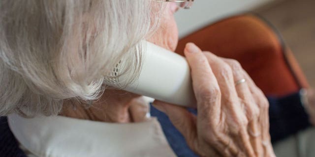 Photo of a woman on the phone who may be speaking to scammers and asking for personal information.