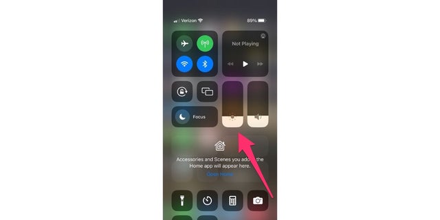The brightness will adjust itself according to the light in the surrounding environment. The less light around you, the dimmer your screen will be.