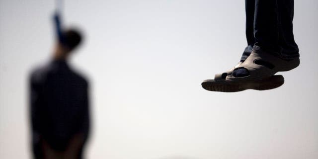 Majid Kavousifar and Hossein Kavousifar, his nephew, hang from the cable of a crane in Tehran August 2, 2007.