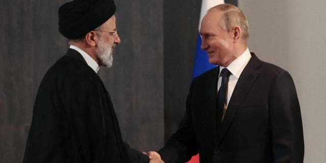 Russian President Vladimir Putin shakes hands with Iranian President Ebrahim Raisi during the Shanghai Cooperation Organization summit in Samarkand, Uzbekistan, on Sept. 15, 2022.