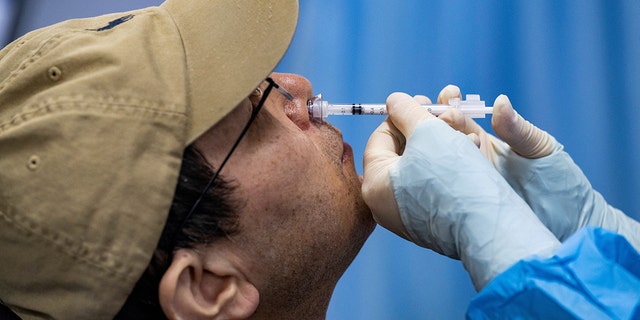 A resident receives a nasal spray vaccine as a second booster shot against coronavirus disease (COVID-19) at a vaccination center in Beijing, China, on December 16, 2022. 