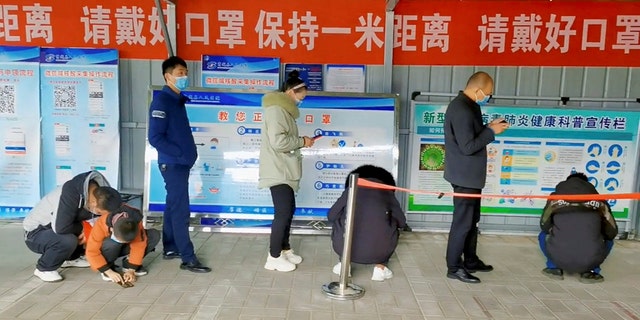 People wait in line at a testing center for the coronavirus disease (COVID-19) in Xinyang, China.  This still image is from a social media video posted on December 15, 2022.   