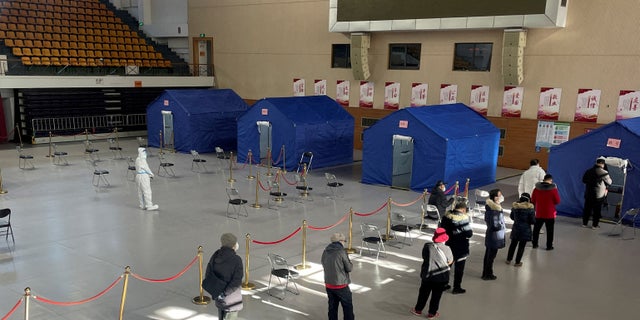 People line up at a makeshift fever clinic set up inside a stadium amid the COVID-19 outbreak in Beijing, China, Dec. 19, 2022.