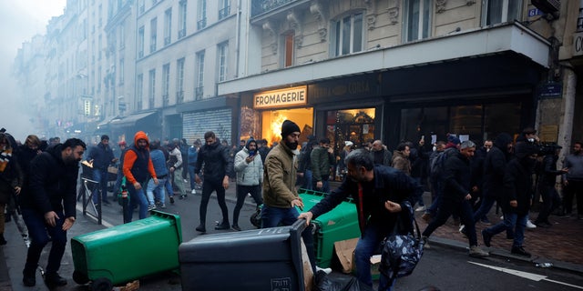 Protestors clash with French police during a demonstration near the Rue d'Enghien after gunshots were fired killing and injuring several people in a central district of Paris Dec. 23, 2022.  