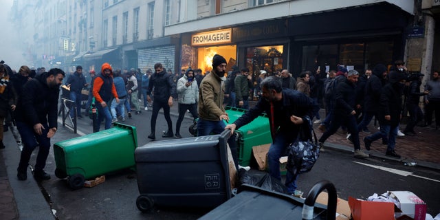 Protesters clash with French police during a demonstration near the Rue d'Enghien after gunshots were fired earlier Friday, killing and injuring several people in a central district of Paris.