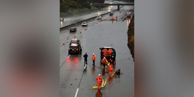 The three right lanes of traffic on westbound 580 near 35th Avenue are blocked while crews try to clear the roadway of major flooding as a strong atmospheric river moves over Oakland, California.