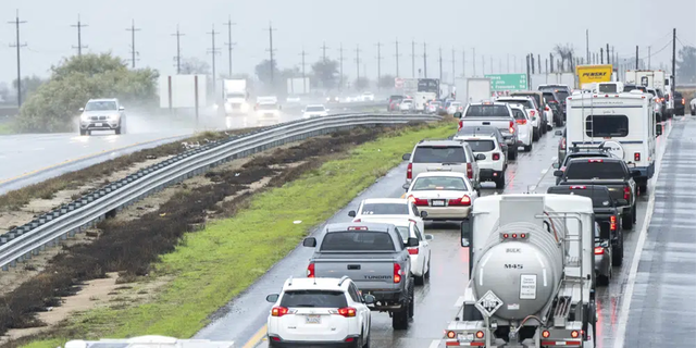 Cars are stopped in the northbound lanes of Highway 101 after flooding closed the highway near Chualar, California.