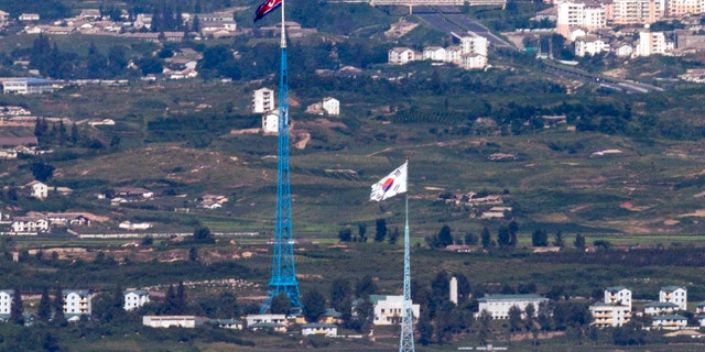 Flags of North Korea, rear, and South Korea, front, flutter in the wind as pictured from the border area between two Koreas in Paju, South Korea. 