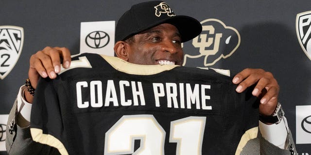 Deion Sanders holds up a jersey before speaking after being introduced as the new head football coach at the University of Colorado during a news conference Sunday, Dec. 4, 2022, in Boulder, Colo. Sanders left Jackson State University after three seasons at the helm of the school's football team.