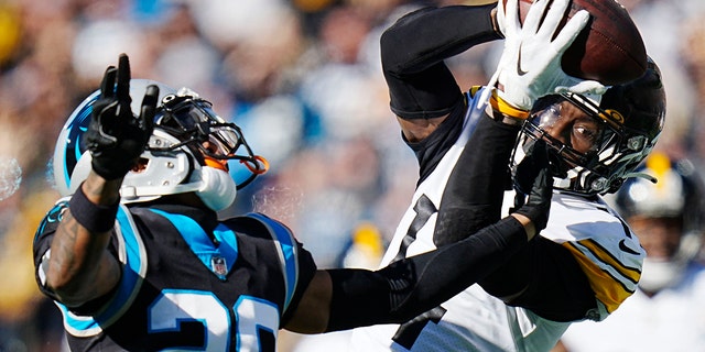 Pittsburgh Steelers wide receiver George Pickens catches a pass over Carolina Panthers cornerback Keith Taylor Jr. during the first half of an NFL football game between the Carolina Panthers and the Pittsburgh Steelers on Sunday, Dec. 18, 2022, in Charlotte, N.C. 