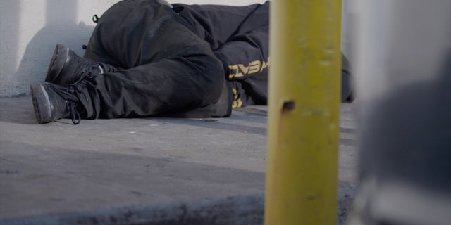 An addict lies on the sidewalk in Kensington. Rodriguez laments that they're seen as just parts of the neighborhood's landscape.