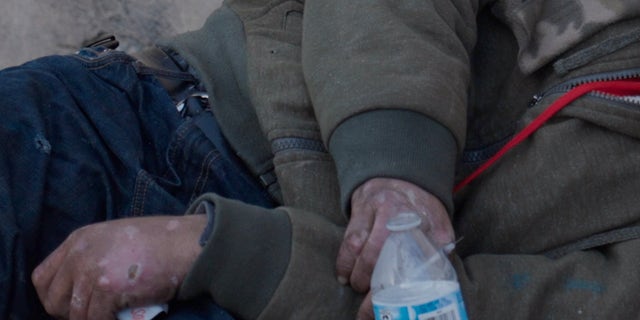 Rodriguez stirred an addict passed out on the sidewalk. An uncapped needle can be seen in his dirt-encrusted, scab-covered hand.