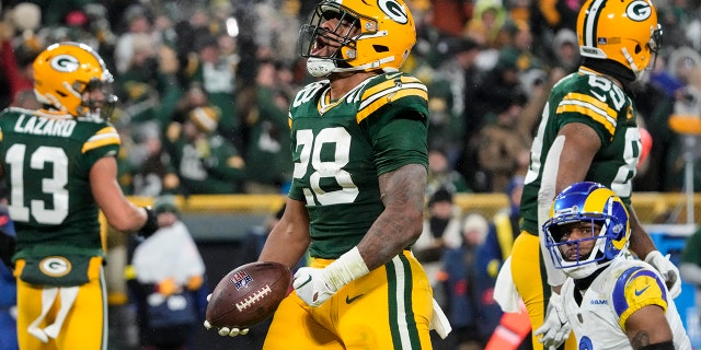 Green Bay Packers running back AJ Dillon (28) celebrates a touchdown against the Los Angeles Rams in the second half of an NFL football game in Green Bay, Wis. Monday, Dec. 19, 2022. 