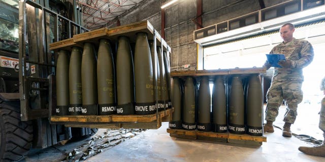 U.S. Air Force Staff Sgt. Cody Brown, right, with the 436th Aerial Port Squadron, checks pallets of 155 mm shells ultimately bound for Ukraine, April 29, 2022, at Dover Air Force Base, Delaware.