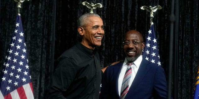 Former President Barack Obama, left, greets Sen. Raphael Warnock, D-Ga., right, before Obama speaks during a rally on Thursday, Dec. 1, 2022, in Atlanta. 