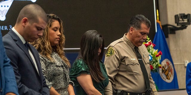 New Los Angeles County Sheriff Robert Luna, right, holds the hand of his wife as they pray with their family before Luna is sworn in as the 34th Los Angeles Sheriff during a ceremony in Los Angeles, Saturday, Dec. 3, 2022. 