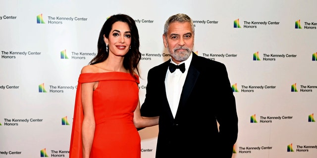 George Clooney and Amal Clooney pose on the red carpet ahead of the Medallion Ceremony.