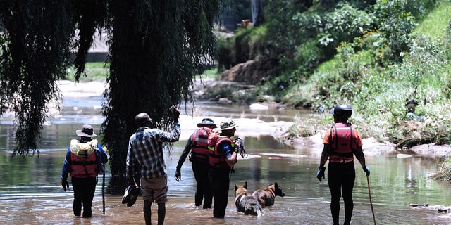 Rescue workers search the waters of the Jukskei river in Johannesburg, Sunday, Dec. 4, 2022. 