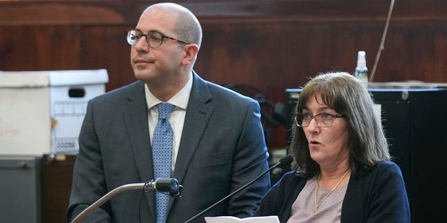 Darlene Altman, daughter of Diane Cusick, reads a statement with prosecutor Jared Rosenblatt at her side at a courtroom in Mineola, N.Y., Monday, Dec. 5, 2022. Richard Cottingham, the serial murderer known as the "Torso Killer", admitted Monday to killing a Cusick, a 23-year-old woman, outside a Long Island shopping mall in 1968 and four other women decades ago. 