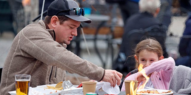 Eden Maracco, 8, has lunch her dad Jeffery while power is out at her home, at Reds Food Truck Corner in Southern Pines, N.C., Monday, Dec. 5, 2022.