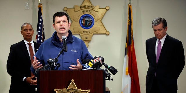 Spokesperson for Duke Energy Corporation Jeff Brooks, center, speaks on Monday, Dec. 5, 2022, at a news conference about an attack on critical infrastructure that has caused a power outage to many around Moore County.