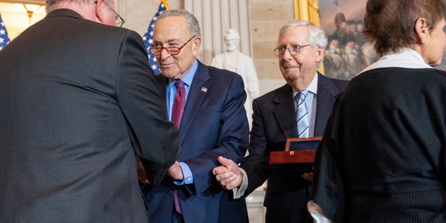 Craig Sicknick, left, brother of slain US Capitol Police Officer Brian Sicknick, is greeted by Senate Majority Leader Chuck Schumer of New York, with Senate Minority Leader Mitch McConnell of Kentucky and Gladys Sicknick, right, the mother of the Sicknicks. The members of the Sicknick family declined to shake hands with McConnell and House Minority Leader Kevin McCarthy of Calif.