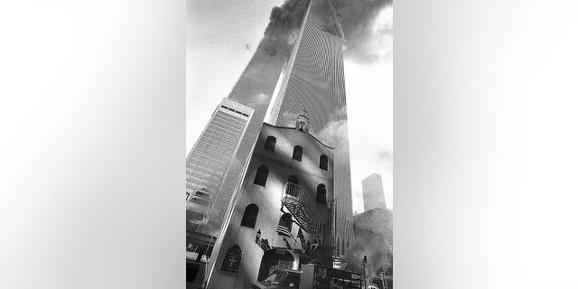 Smoke billows from the World Trade Center towers as St. Nicholas Greek Orthodox Church sits below the towers in New York's Financial District.