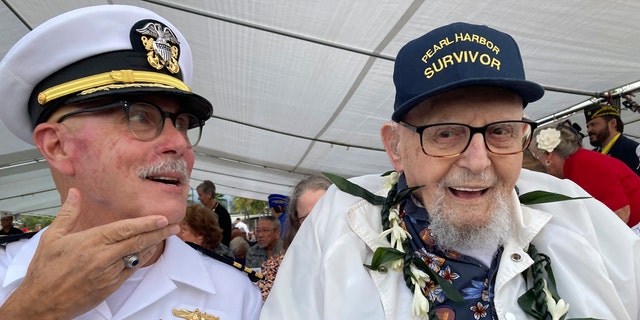 Ira Schab, 102, right, who survived the attack on Pearl Harbor as a sailor on the USS Dobbin, talks with reporters while sitting next to his son, retired Navy Cmdr. Karl Schab, Wednesday, Dec. 7, 2022, in Pearl Harbor, Hawaii. 