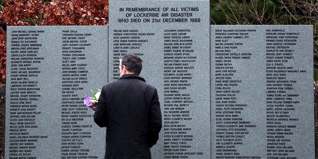 FILE: A man looks at the main memorial stone in memory of the victims of the bombing of Pan Am flight 103, in the garden of remembrance near Lockerbie, Scotland Friday Dec. 21, 2018.