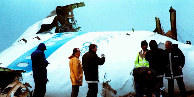 Crash investigators inspect the nose section of the crashed Pan Am flight 103, a Boeing 747 airliner in a field near Lockerbie, Scotland, Dec. 23, 1988. 