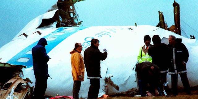 Crash investigators inspect the nose section of the crashed Pan Am flight 103, a Boeing 747 airliner in a field near Lockerbie, Scotland, Dec. 23, 1988. 