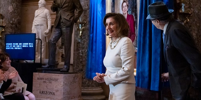 До спікера Палати представників Ненсі Пелосі, штат Каліфорнія, приєднується її чоловік Пол Пелосі, коли вони відвідують відкриття її портрета в Залі статуй Капітолію у Вашингтоні, середа, 14 грудня 2022 року. 